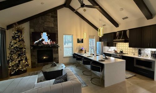 Cabin living room with a Christmas tree next to a lit fireplace