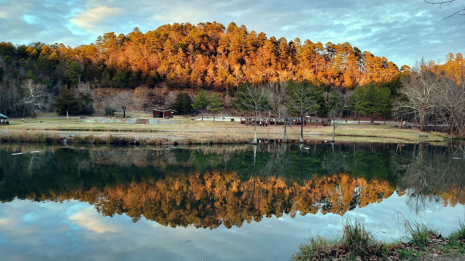 Golden fall color on the ridge reflected in the water at Beavers Bend State Park, Oklahoma