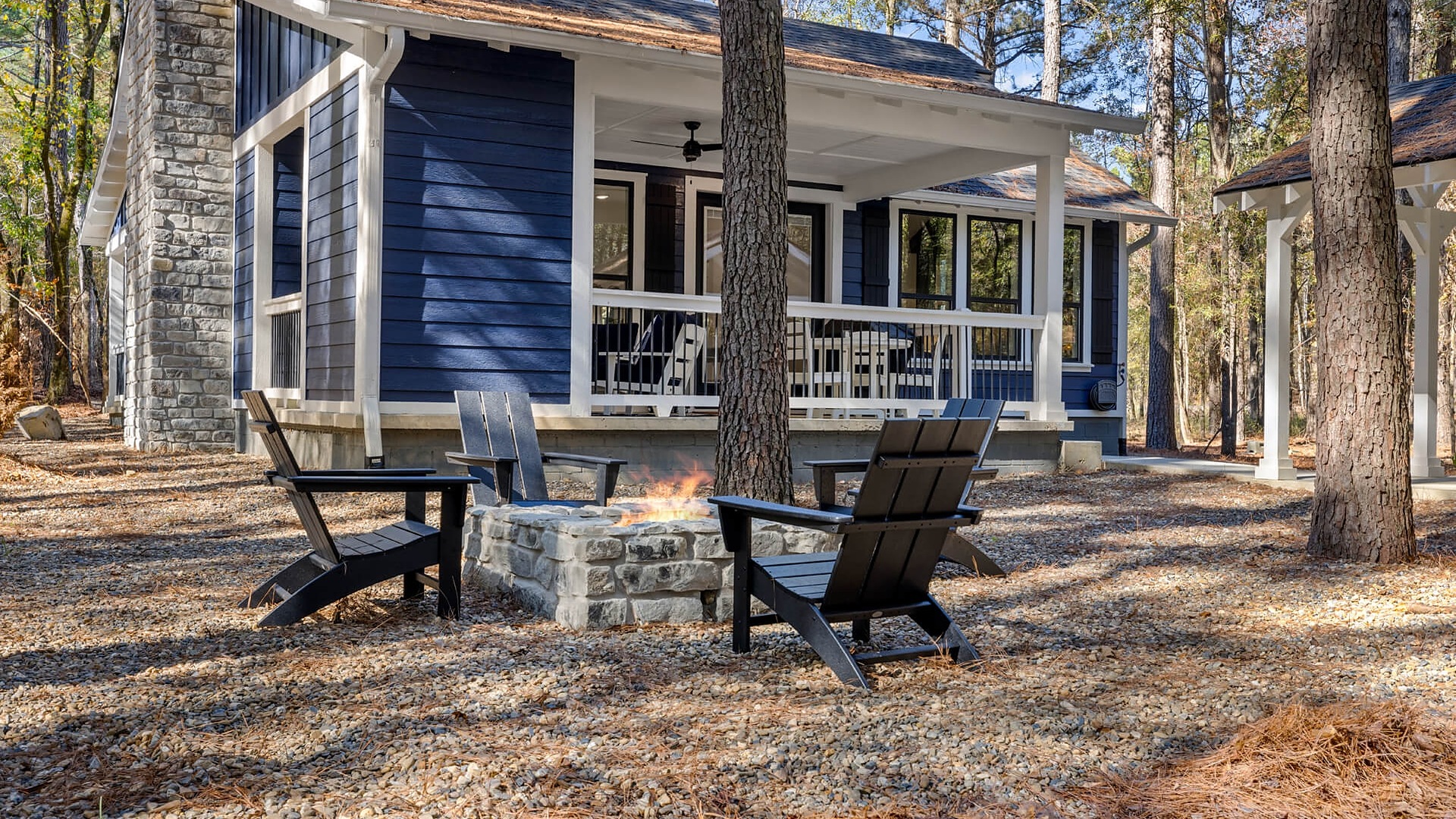 Fire pit with Adirondack chairs outside Blue Creek Cottage in Broken Bow