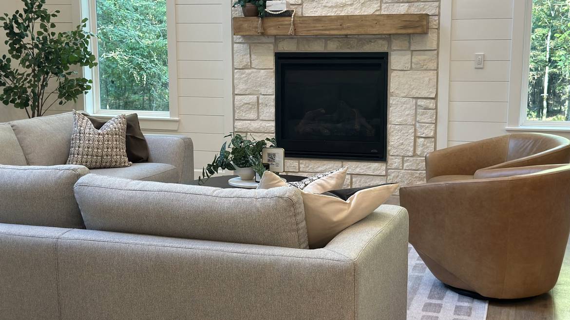Living room with a stone fireplace in a Three Creeks Reserve cabin