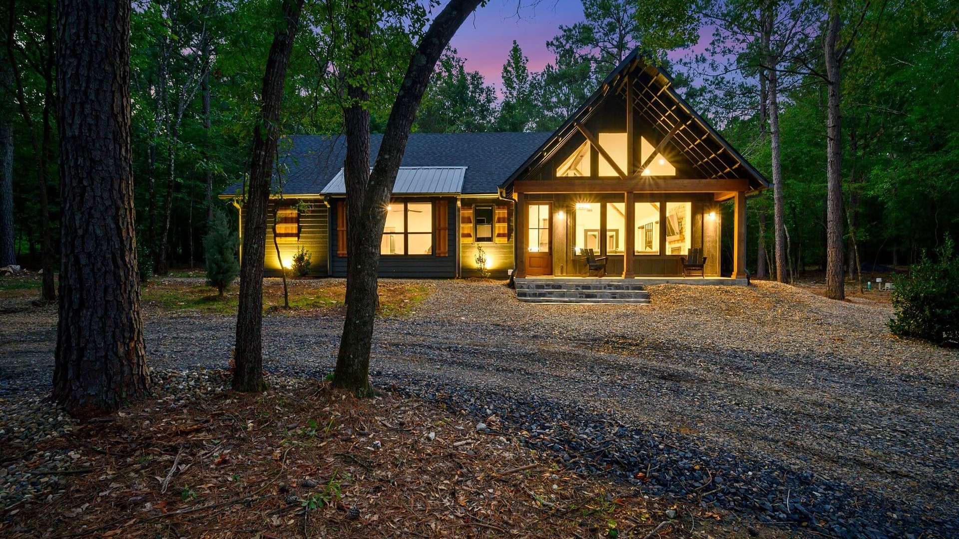 The Black Pearl cabin lit up at dusk among the pines in Broken Bow