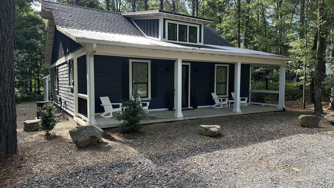 Three Creeks Reserve cabin with a covered front porch surrounded by pines in Broken Bow
