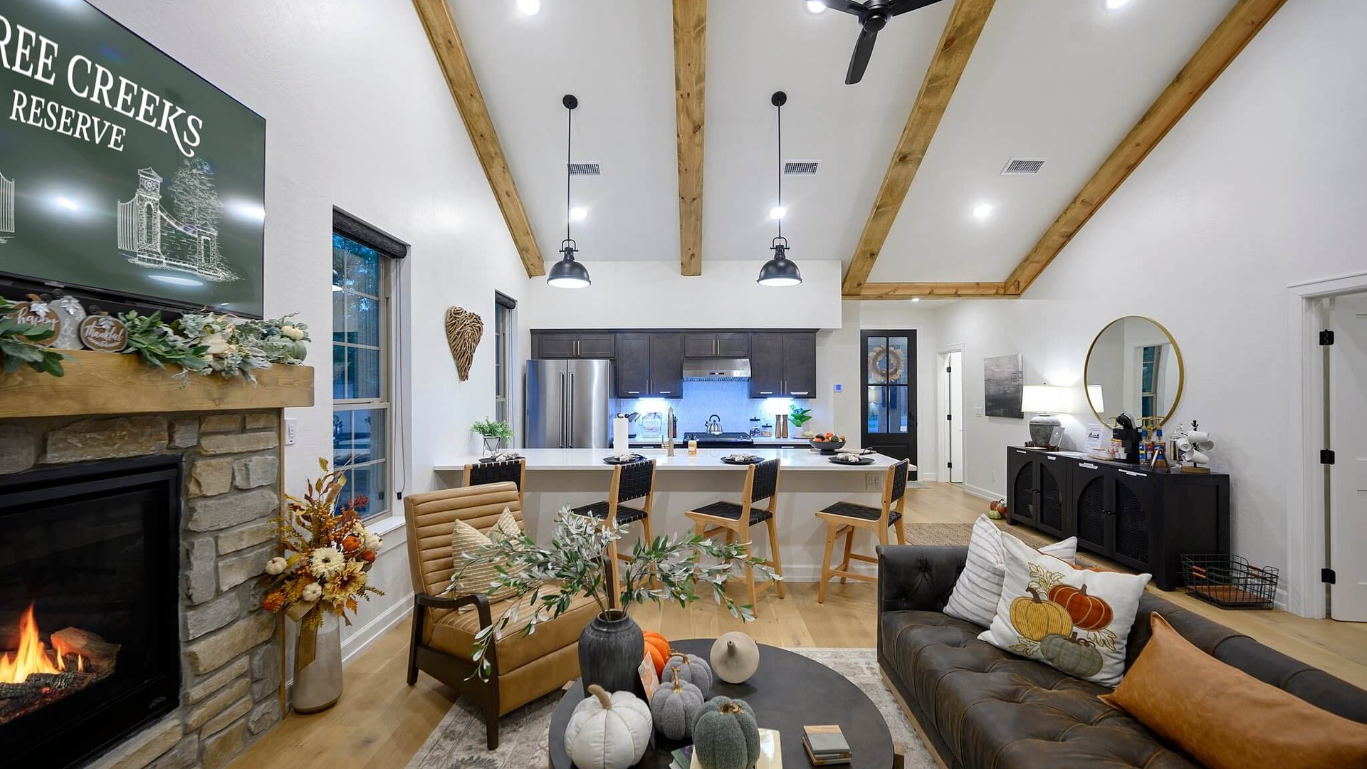 Fall-decorated living room with a stone fireplace at Three Creeks Cottage in Broken Bow
