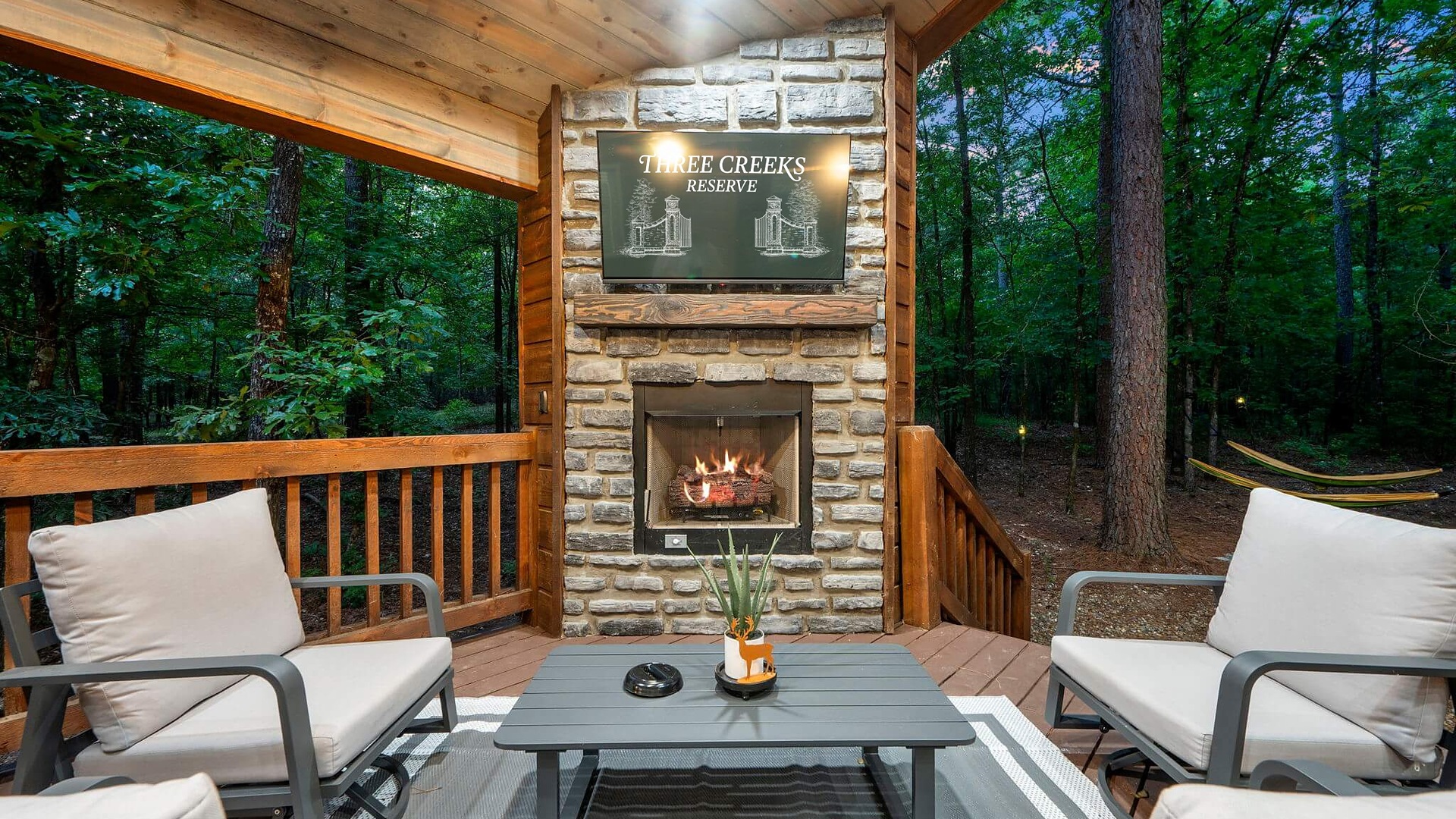 Back porch fireplace and seating at Up Deer Creek cabin in Broken Bow